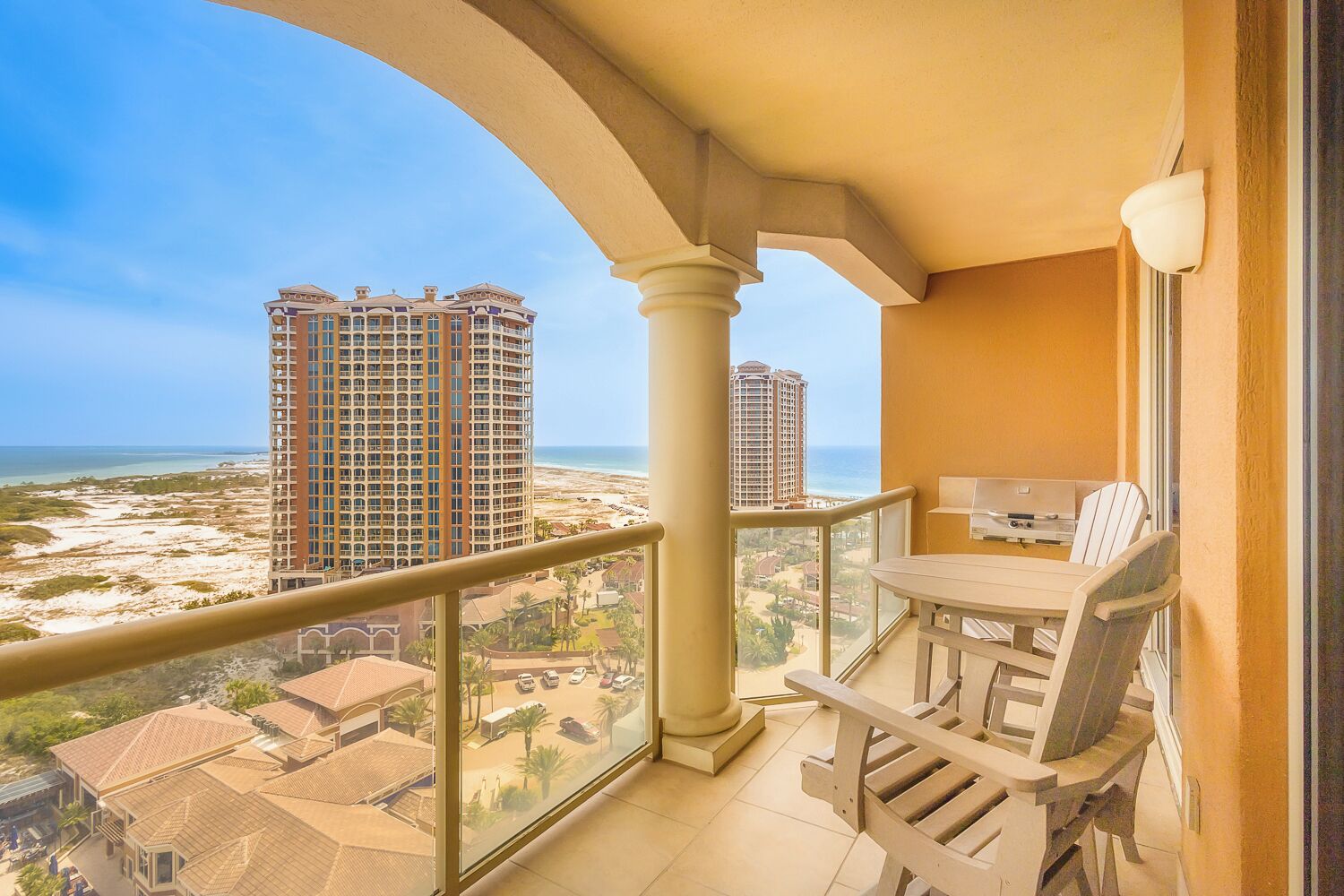 Un balcon avec vue sur une plage et des immeubles de grande hauteur.