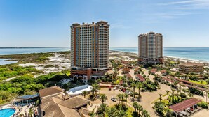 A resort with two tall buildings, a beach, and a pool area. - Last Minute Rates! Tower 4 2B Island View at Portofino! (Pensacola Beach)