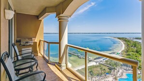 A balcony with a view of a beach and a pool. - Last Minute Rates! Tower 4 2B Island View at Portofino! (Pensacola Beach)
