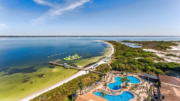 A resort with a large swimming pool, a dock with boats, and a beach area. - Last Minute Rates! Tower 4 2B Island View at Portofino! (Pensacola Beach)