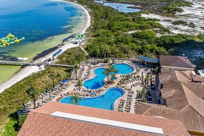 Relax by the large pool surrounded by sun loungers and shaded areas, with access to a beach with clear waters and a sandy shore.
