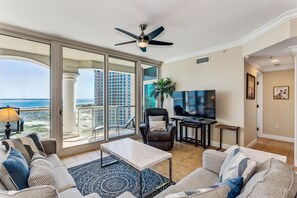 Relax in a spacious living room with a sofa, armchairs, and flat-screen TV.