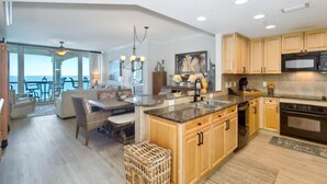 A modern kitchen with granite countertops, wooden cabinets, and a built-in oven.