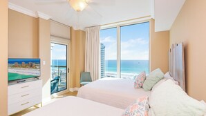 A hotel room with a balcony, a television, and a bed with pillows. - Great Gulf Views @ Portofino 4-1606! (Pensacola Beach)