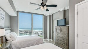 A hotel room with two beds, a ceiling fan, a TV, and a view of the beach. - P5-0608 2B Gulf Front Tower 5 (Pensacola Beach)