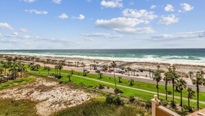 A coastal road with palm trees, a beach, and the ocean. - P5-0608 2B Gulf Front Tower 5 (Pensacola Beach)