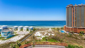 Un hotel costero con varias edificaciones, vista a la playa y una gran piscina.