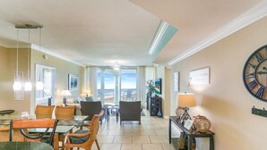 Un hall d’hôtel comprenant un espace repas, des canapés, une horloge et une vue sur l’extérieur à travers les portes vitrées.
