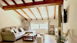 A living room with a sofa, coffee table, and a TV mounted on the wall. - Apartment 85m2 luxury residence sea view 6 people 2 bedrooms (Porto-Vecchio)