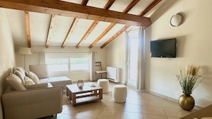 A living room with a sofa, coffee table, and TV. - Apartment 85m2 luxury residence sea view 6 people 2 bedrooms (Porto-Vecchio)