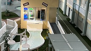 Atrio interno con elemento d'acqua, sala giochi e area piscina.