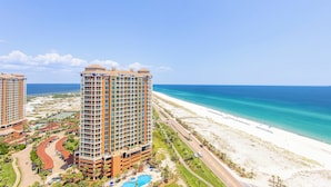 Een hoog hotel met zwembad en uitzicht op het strand.
