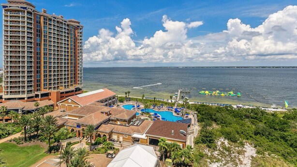 A resort with a large building, a swimming pool, and a view of the ocean. - P2-1007 3B Gulf View Condo - Sleeps 10! Great for Families! (Pensacola Beach)