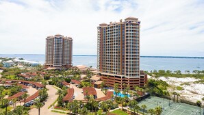 Un resort con due edifici a grattacielo, un'area parcheggio e vista sulla spiaggia.