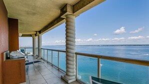Un balcon avec vue sur l’océan, doté d’une balustrade et d’un espace salon comprenant une table et des chaises.
