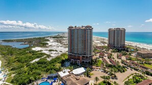 Un complexe hôtelier comprenant deux immeubles de grande hauteur, une plage et un espace piscine.