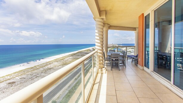 Ein Balkon mit Blick auf Strand und Meer.