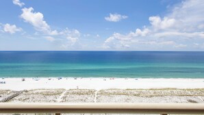 Ein Strand mit blauem Himmel, sandigem Ufer und ruhiger See.