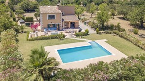 A two-story house with a swimming pool, surrounded by lush greenery and a hilly landscape. - Villa Miravall Selva by Balearic Villas (Selva)