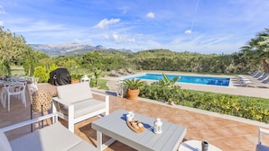 A patio with outdoor furniture, a pool, and a view of mountains. - Villa Miravall Selva by Balearic Villas (Selva)