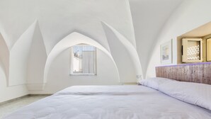 Une chambre à coucher avec un grand lit, une fenêtre et une tête de lit en bois.