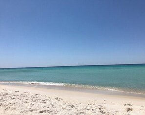 Ein Strand mit klarem türkisblauem Wasser und einem Sandstrand.