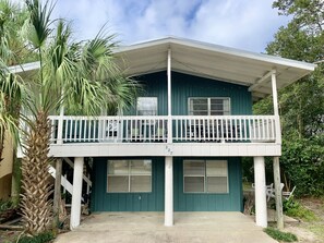 Une maison à deux étages avec un balcon, un garage et un petit espace porche.