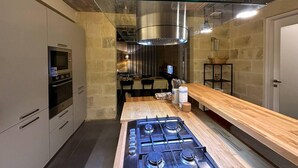 A modern kitchen with a gas stove, built-in oven, and stainless steel appliances. - Heritage Living Apartment With Spectacular Views (Zebbug)