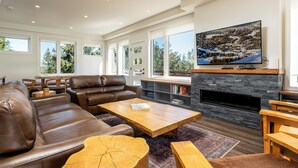 A modern living room with a leather sofa, wooden coffee table, and a fireplace.