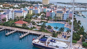 A marina with colorful buildings, a swimming pool, and a yacht docked. - 2 Bedroom Lock-out - Harborside Resort at Atlantis - Full Resort Access (Paradise Island)