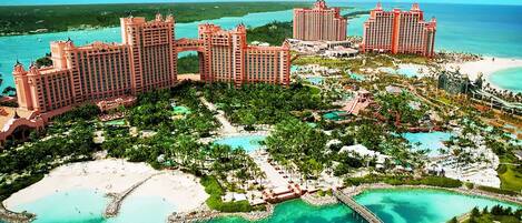 A resort with multiple high-rise buildings, a central pool area, and a beach.