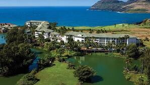 A resort with multiple buildings, a golf course, and a body of water.