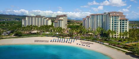 A resort with beachfront properties, a sandy beach, and a clear blue sea.