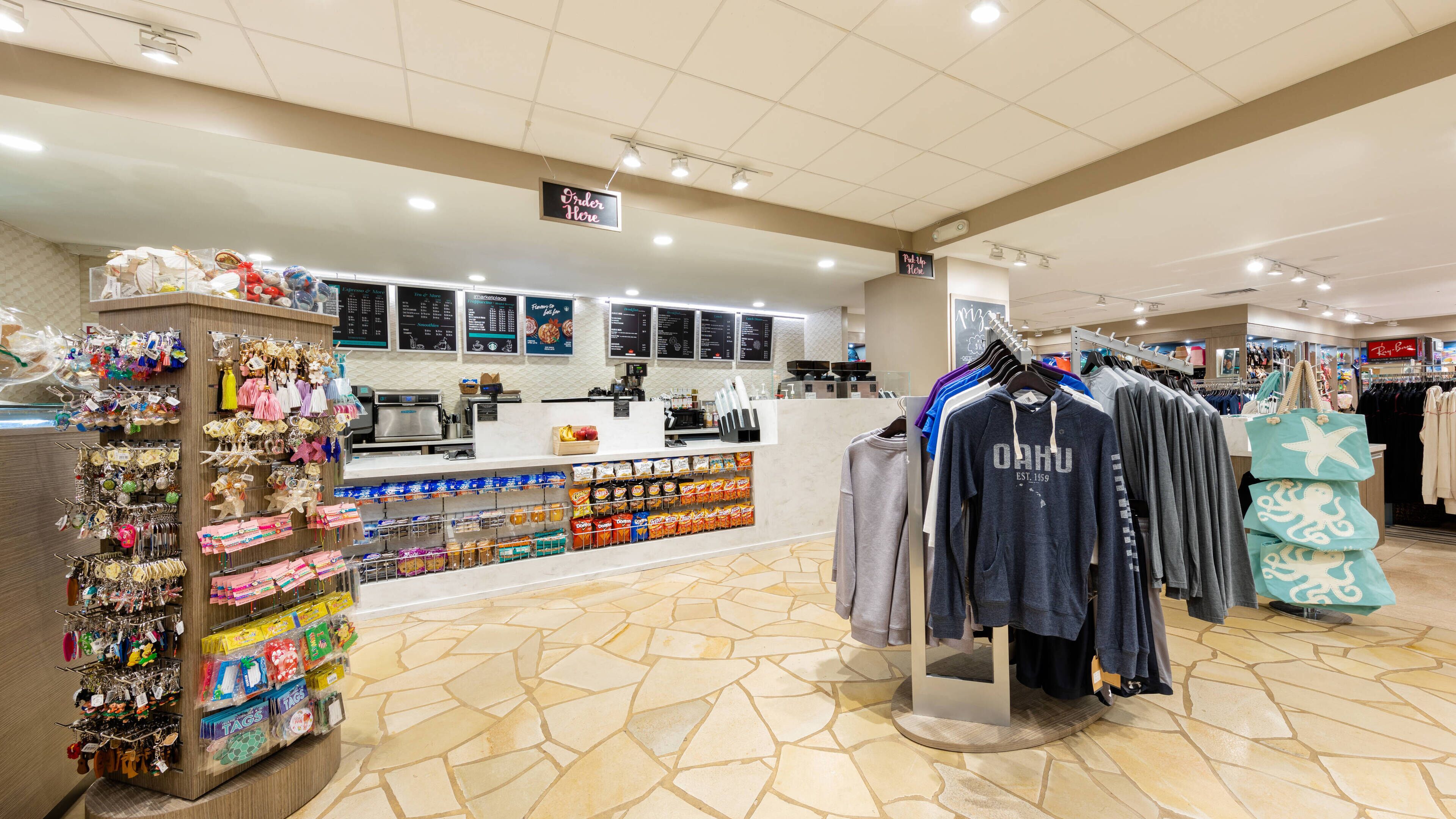 Un magasin de détail doté d’un comptoir de caisse, d’un présentoir de collations et de portants à vêtements.