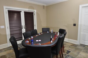 A conference room with a rectangular table, black chairs, and a bottle of liquor.