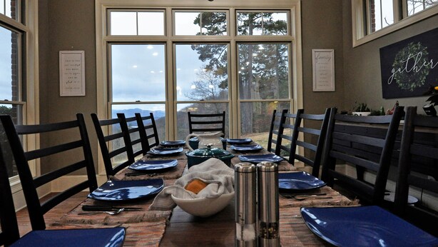 A dining area with a large window, a chandelier, and a menu board. - Unwine'd With a View (Hayesville)