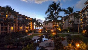 A resort with multiple-story buildings, a central courtyard with a water feature, and palm trees.