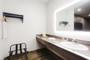 A modern bathroom with a large mirror, a sink, and a towel rack. - Palace Inn Baytown Spur TX-330 (Baytown)