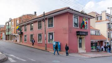 Um edifício rosa com várias janelas e uma placa de hotel.