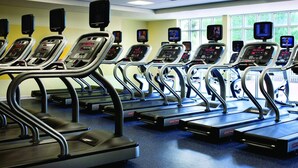 A row of treadmills with digital displays, arranged in a gym with large windows and a blue carpet. - Oceanfront - Studio - Marriott's Aruba Surf Club - Full Resort Access (Palm Beach)