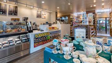 A bakery section with various baked goods and a display of ceramic tableware.