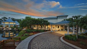 A resort with a lake, a covered walkway, and a large building with a blue roof.