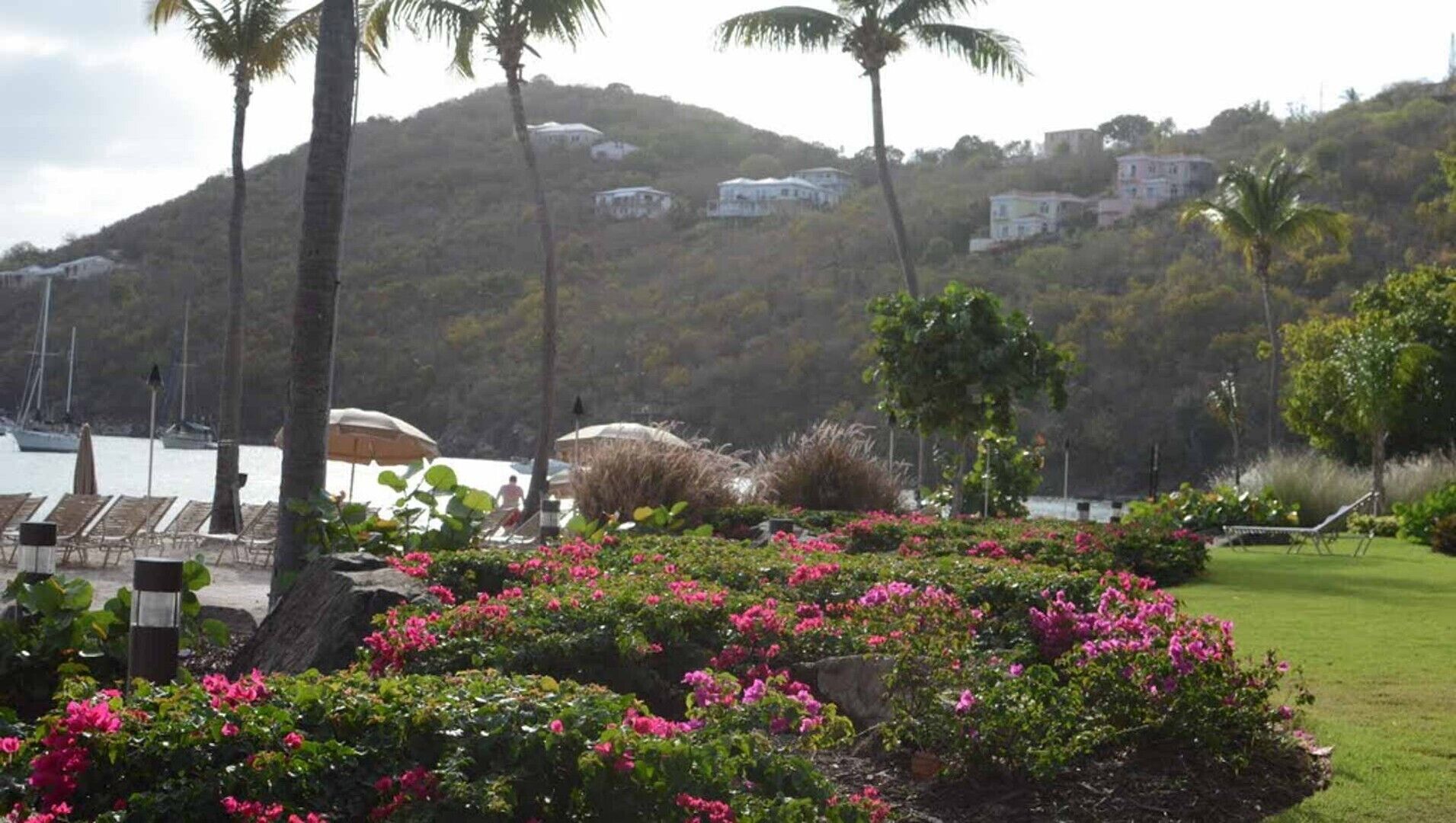 A resort with a pool area, lounge chairs, and a hillside view.