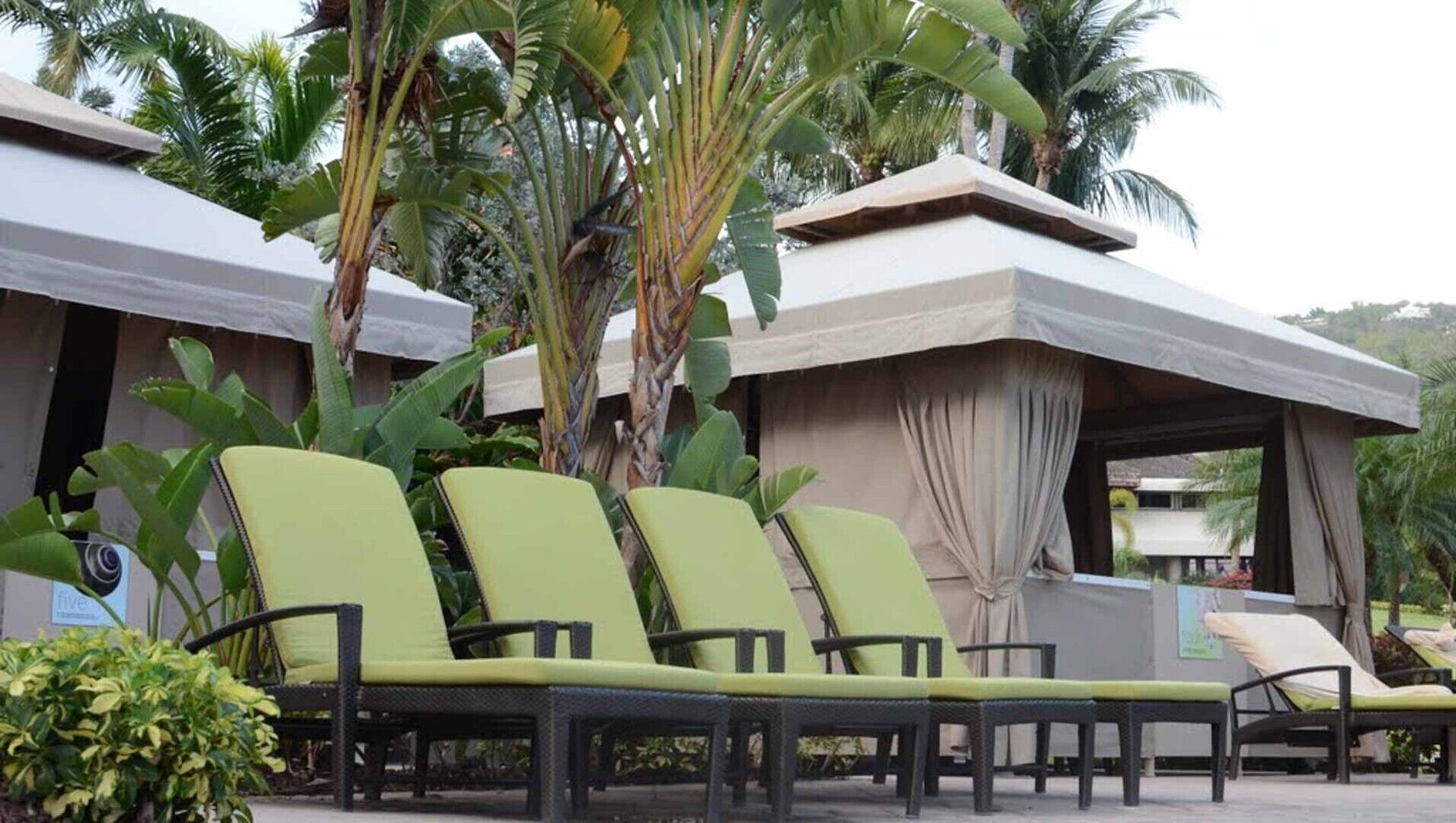 A poolside area with lounge chairs and a covered seating area.