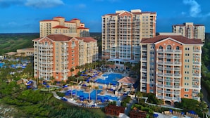 A resort with multiple high-rise buildings, a central swimming pool, and surrounding greenery. - Oceanside - 2 Bedroom - Marriott's OceanWatch Villas at Grande Dunes - Full Resort Access (Myrtle Beach)