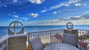 A balcony with a view of the ocean, featuring a white railing, a metal table, and two chairs. - Oceanfront - 2 Bedroom - Marriott's OceanWatch Villas at Grande Dunes - Full Resort Access (Myrtle Beach)