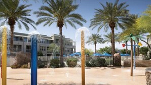 A water feature with multiple jets, palm trees, and a building with balconies in the background. - 1 Bedroom - Marriott's Canyon Villas at Desert Ridge - Full Resort Access (Phoenix)