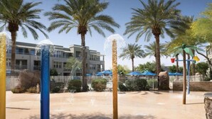 A water feature with multiple jets, palm trees, and a building with balconies in the background. - 2 Bedroom - Marriott's Canyon Villas at Desert Ridge - Full Resort Access (Phoenix)
