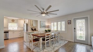 A spacious kitchen with a dining area, a ceiling fan, and a view through the window. - Bliss Near Beach w/ Guest House + Salt Heated Pool (Boynton Beach)