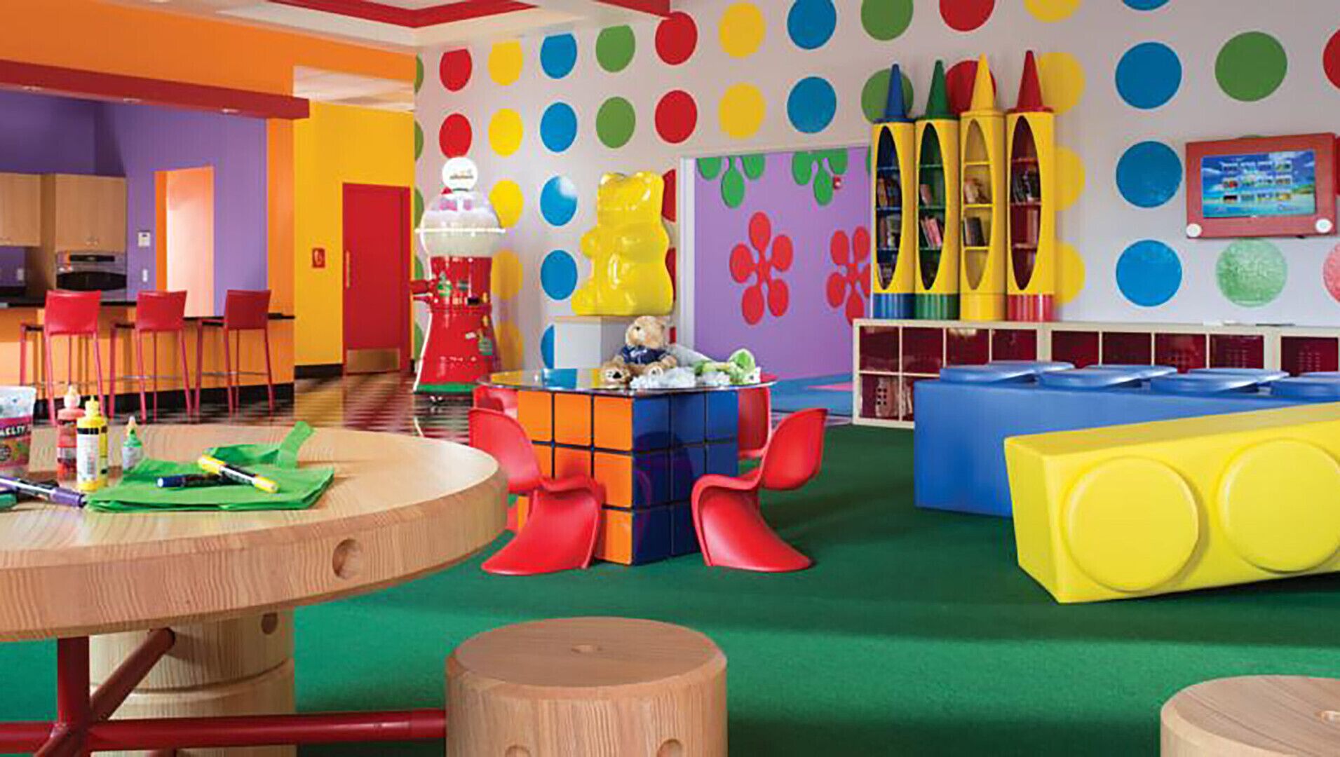 A colorful children's play area with a round table, chairs, and various toys.
